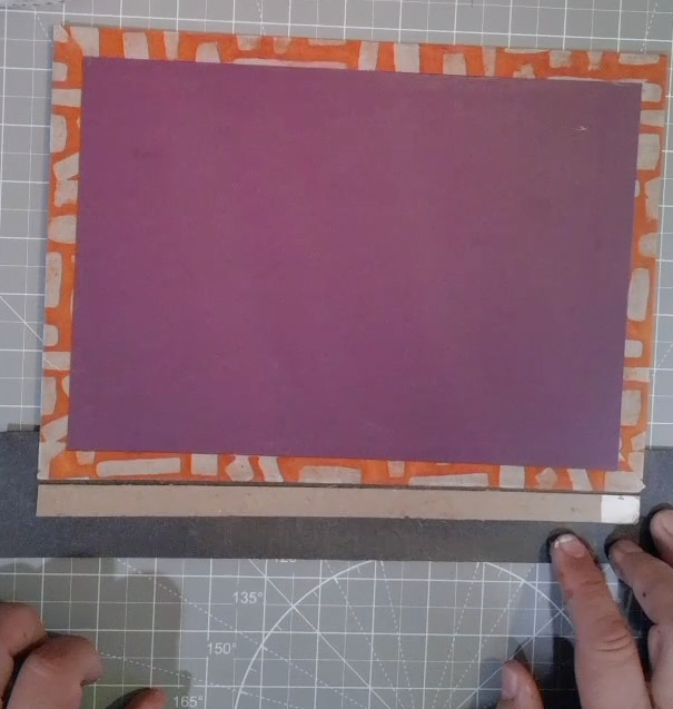 An unassembled book cover on a craft mat.